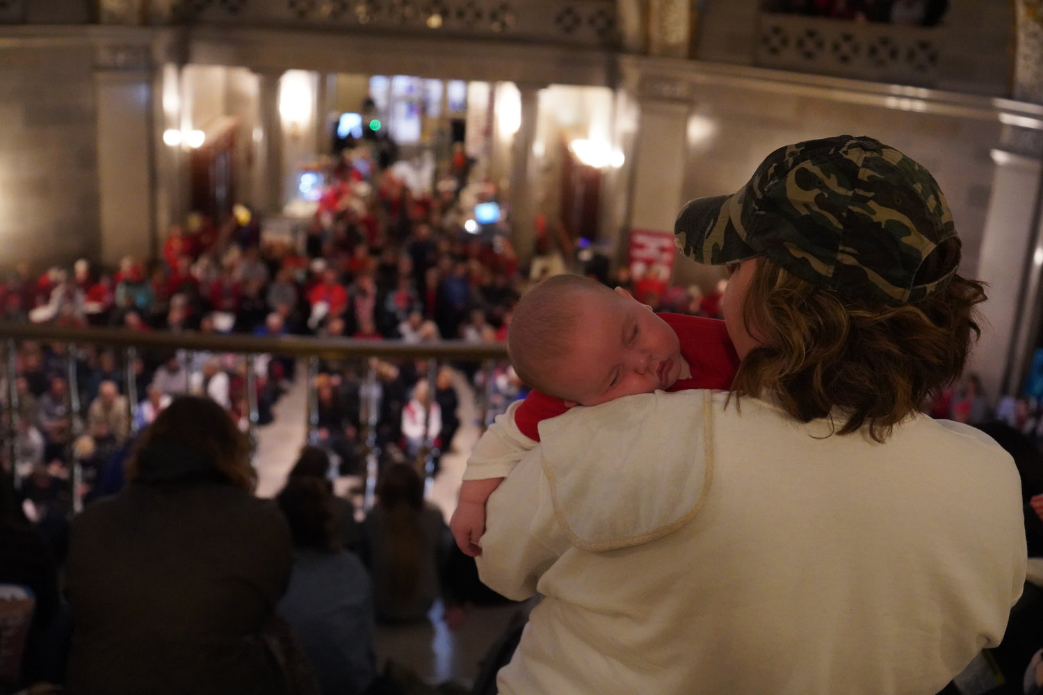 A mother from the Jefferson City diocese rocks her sleeping baby while keynote speaker Abby Johnson addresses a crowd of over 2,000 at an April 20 rally in the Missouri State Capitol Rotunda as part of the 2022 Midwest March for Life.
